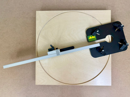Wooden board with a circular cutout and a tool for routing circles sitting on the board 