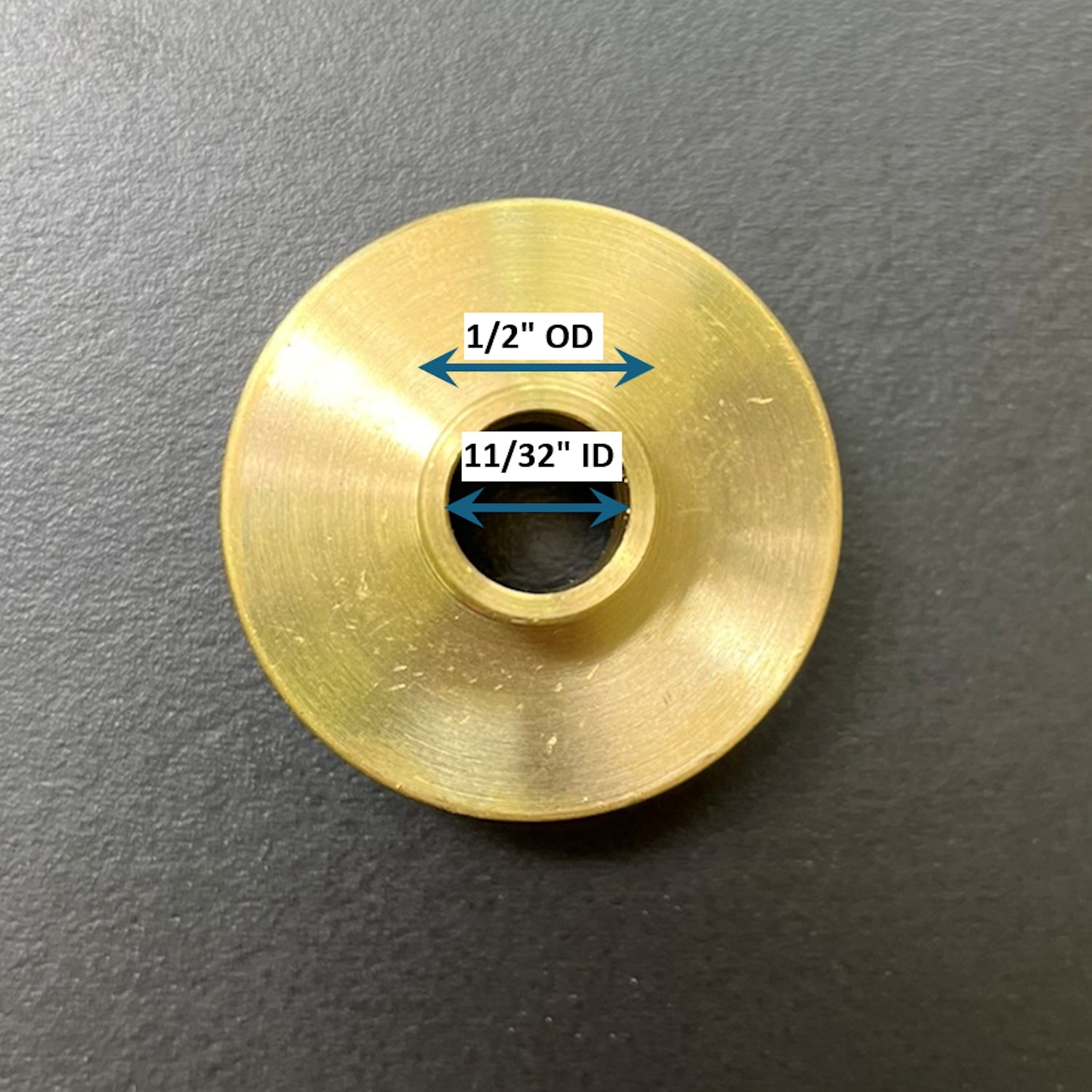 Gold metal bushing with measurements on a gray background