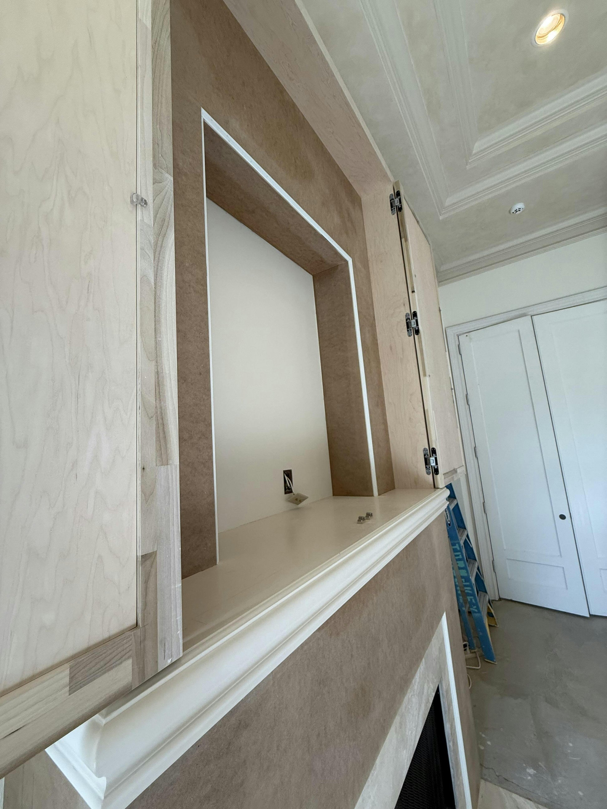 Wooden wall paneling with a built-in mirror in a room with white walls and a ceiling light.