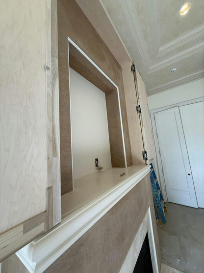 Wooden wall paneling with a built-in mirror in a room with white walls and a ceiling light.