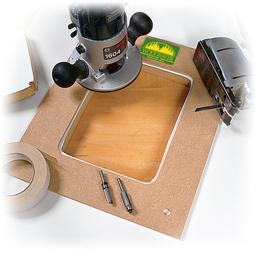 A router plate template made of MDF displayed on a table with a router, tape measure, and other tools for woodworking.