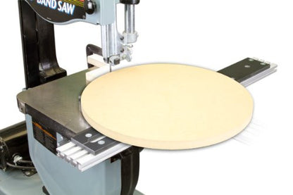 A band saw circle cutting jig in use, where a circular piece has been cut from the wood that is mounted on the saw's blade.