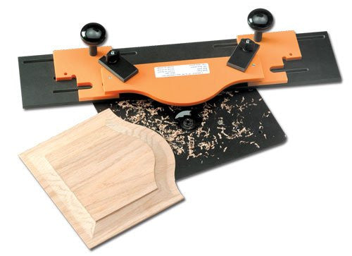 An orange and black door jig and template kit, with a router bit and a piece of wooden door panel lying beside it.