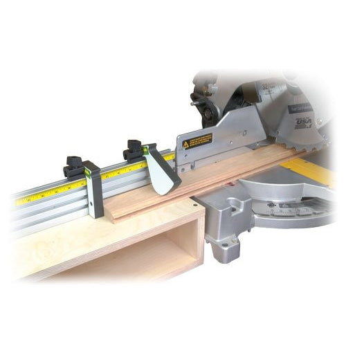 An image showing a chop saw with a miter saw fence kit installed on it, with various components of the kit visible, such as metal tracks and flip stops.