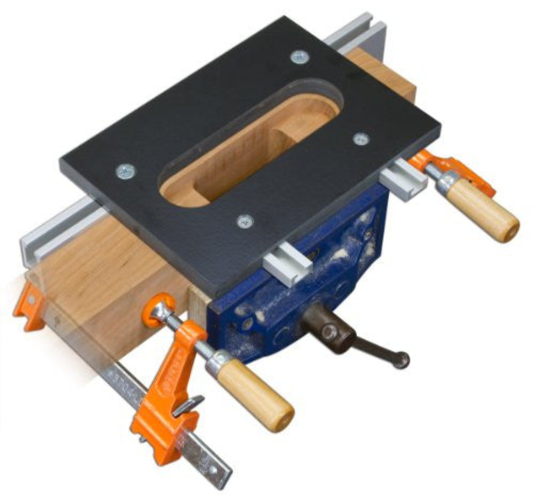 A phenolic router hinge jig with a double track and two orange clamps mounted on a wooden piece, designed for cutting mortises for a SOSS hinge.