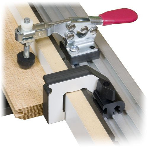 A flip stop attached to a miter saw, designed for locating parts on a coping sled, with a red handle and metallic finish.